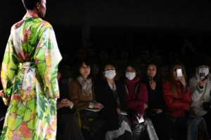 Guests wear masks as a model presents a creation by Dries Van Noten during the Women's Fall-Winter 2020-2021 Ready-to-Wear collection fashion show in Paris. By Anne-Christine POUJOULAT (AFP)