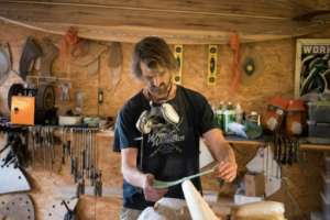 Hand-made: Patrick Burnett sands a wooden surfboard in his workshop, near Cape Point. By RODGER BOSCH (AFP)
