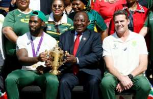 South African President Cyril Ramaphosa holds the Rugby World Cup trophy with Springboks captain Siya Kolisi. By Phill Magakoe (AFP)