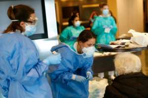 Health care workers attend to a COVID-19 patient at the Hotel Melia Barcelona Sarria, which has been converted into a hospital. By PAU BARRENA (AFP)