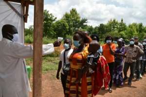 Health ministry workers in Bouake, Ivory Coast check passengers' temperatures to prevent Covid in June 2020. By Issouf SANOGO (AFP/File)