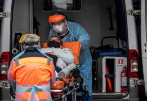 Health workers carry a patient with symptoms of the new COVID-19 coronavirus from an ambulance into a hospital in Santiago. By MARTIN BERNETTI (AFP)