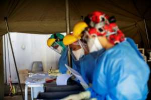 Health workers fill out documents before performing tests for COVID-19 coronavirus on other health workers at the screening and testing tents set up at the Charlotte Maxeke Hospital in Johannesburg. By Michele Spatari (AFP)