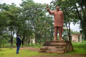 Historian Guillaume Nkongolo stands by Lumumba's statue, at a neglected memorial in Katanga. By Samir Tounsi (AFP)