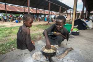 Homeless: Children prepare maize at an IDP camp in Bangula, southern Malawi. By AMOS GUMULIRA (AFP)