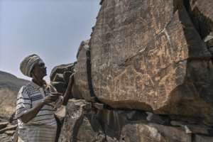 Ibrahim Dabale Loubak, guardian of rock art, tells the story told through ancient representations of wildlife and cultural practices, near the Djibouti-Ethiopian border.  By TONY KARUMBA (AFP)