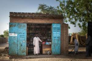 Ibrahim Hassan, a 42-year-old Sudanese trader and refugee in Treguine, poses in front of his shop in the adjoining town of Hadjer Hadid. By Amaury HAUCHARD (AFP)