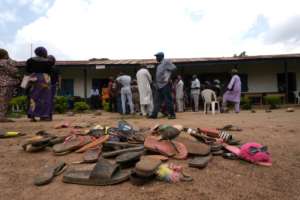 In the schoolyard, parents picked up shoes and flip flops that their kidnapped children left behind.  By Kola Sulaimon (AFP)