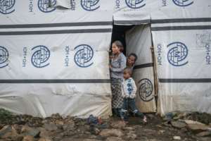 Internally displaced people stand at the entrance of a shelter at the Azezo camp. By EDUARDO SOTERAS (AFP)
