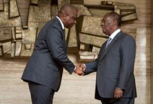 Ivory Coast's newly appointed Prime Minister Hamed Bakayoko (left) shakes President Alassane Ouattara. By CIbouT (IVORIAN PRESIDENCY/AFP)