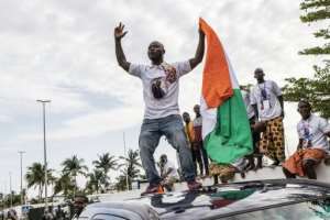 Joy: Gbagbo supporters celebrate as his plane lands. By JOHN WESSELS (AFP)