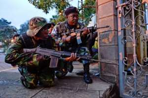 Kenyan soldiers take cover as heavy gunfire breaks out during the siege. By CARL DE SOUZA (AFP)