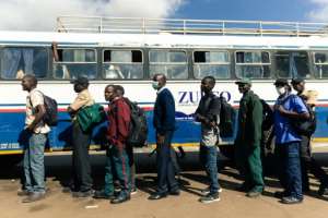 Key workers exempted from the lockdown prepare to board a government-subsidised bus in Harare. By Jekesai NJIKIZANA (AFP)