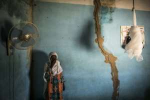 Khady, who lives on the outskirts of the forest, stands next to cracks in her walls caused by explosions from the quarry. By JOHN WESSELS (AFP)