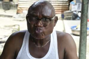 Kingdom Adugbo delivers his verdict after sipping from a glass of ogogoro. By PIUS UTOMI EKPEI (AFP)