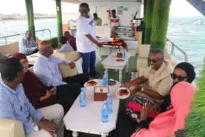 La Lanterna owner Abdulkadir Mohamed Ibrahim serves customers on board his floating restaurant. By Abdirazak Hussein FARAH (AFP)