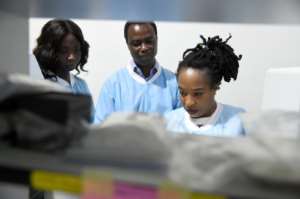 Laboratory manager Philomena Eromon, right, joins molecular biologists to analyse coronavirus samples. By PIUS UTOMI EKPEI (AFP)