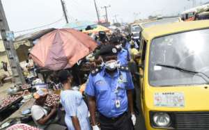 Lagos Police Commissioner Hakeem Odumosu squeezes his way through a market to monitor compliance with measures to curb the spread of coronavirus. By PIUS UTOMI EKPEI (AFP)