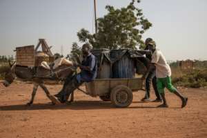 Latrine workers haul away barrels filled with human waste -- Ouagadougou's sewage farms are located far away, which means the contents often get dumped on land on the city's outskirts. By OLYMPIA DE MAISMONT (AFP)