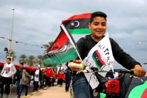 Libyans processed through the capital Tripoli waving the national flag as part of celebrations marking the anniversary of the 2011 NATO-backed uprising that toppled longtime dictator Moamer Kadhafi. By Mahmud TURKIA (AFP)