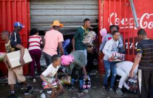 Looters stole items from shops they believed to be foreign-owned during a riot in a Johannesburg suburb. By GUILLEM SARTORIO (AFP)