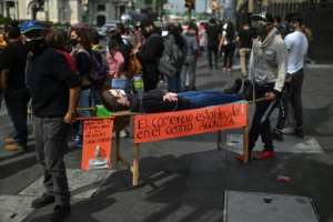 Lockdown protesters carry a mannequin symbolising ailing businesses in Mexico City.. By PEDRO PARDO (AFP)