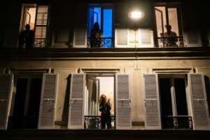Locked down residents in Paris applaud healthcare employees from their windows. By Martin BUREAU (AFP)