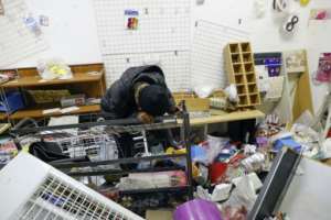 Loss: Thandi Johnson weeps in his looted store at Diepkloof Mall.  By Phill Magakoe (AFP)