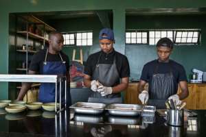 Malonga (left), pictured with colleagues in his Kigali restaurant, says he comes from a family that celebrates food. By Simon MAINA (AFP)