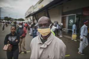 Masked: An elderly man in the Johannesburg suburb of Soweto waits in line at a pay point operated by South Africa's Social Security Agency. By MARCO LONGARI (AFP)