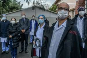 Members of Cerrahpasa Faculty of Medicine in Istanbul hold a minute's silence for their retired colleague Feriha Oz who died from the novel coronavirus. By Bulent Kilic (AFP)