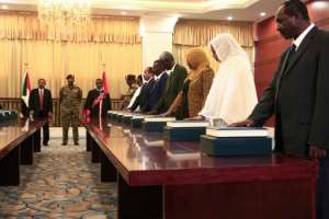Members of the Sudanese cabinet are sworn in in the presence of new Prime Minister Abdalla Hamdok (back-L) and General Abdel Fattah al-Burhan (back-C), the head of Sudan's ruling sovereign council, at the presidential palace in Khartoum. By Ebrahim HAMID (AFP)