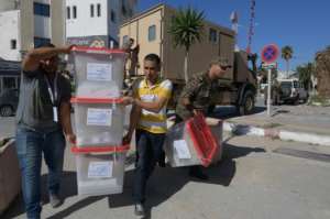 Men from Tunisia's election commission and members of the military deliver blank ballots to a polling station in the capital a day before the presidential runoff. By FETHI BELAID (AFP)