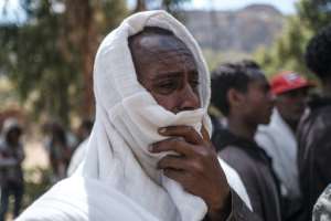 Men in Dengolat covered their faces to weep as women pounded the ground and showed images of their loved ones. By EDUARDO SOTERAS (AFP)
