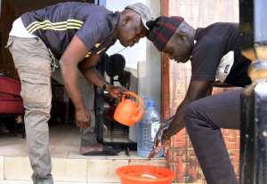 Men wash their hands before entering a restaurant in Dakar. By Seyllou (AFP)