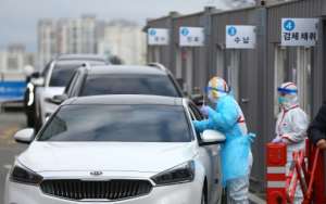 Medical staff take samples from passengers with suspected symptoms of the COVID-19 coronavirus at a drive-through screening clinic of a hospital in Daegu. By - (YONHAP/AFP)