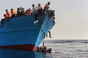 Migrants wait to be rescued by members of the Proactiva Open Arms NGO in the Mediterranean Sea off the coast of Libya on October 4, 2016