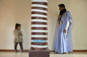Mohamed El Haiba Ahmed Fal (R), a Moroccan engineer who crossed the wall dividing Morocco and the Polisario-administered side of the Western Sahara poses for a photo with his daughter at his home in the Samara refugee camp in the Western Sahara