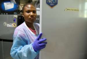 Molecular biologist Iyanuoluwa Fred retrieves a COVID-19 sample from a freezer for analysis. By PIUS UTOMI EKPEI (AFP)