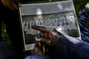 Ngasura, 95, points at a picture of some of the people he was evicted from Kericho with. By TONY KARUMBA (AFP)