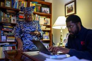 Nigerian Ngozi Okonjo-Iweala is helped by her son Okechukwu Iweala (right) as she works on her acceptance speech at her home in Potomac, Maryland, near Washington DC.  By Eric BARADAT (AFP)