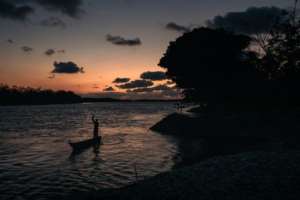 Night falls on Nteva village as a fisherman returns to his home. By ALEXIS HUGUET (AFP)