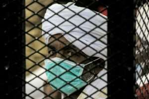 One of the 27 co-accused at the trial of Bashir is pictured inside a caged area of the courthouse. By ASHRAF SHAZLY (AFP)