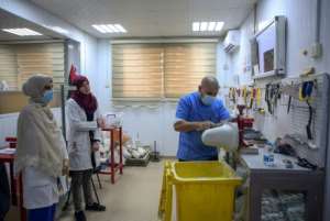 Ortho-prosthetist Badreddine Moftah builds plaster sockets to cover stumps of amputees, as students watch. By Mahmud TURKIA (AFP)