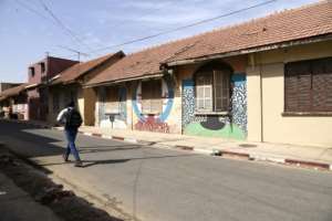 Painting the walls of old colonial buildings is meant to save them as developers move in. By SEYLLOU (AFP)