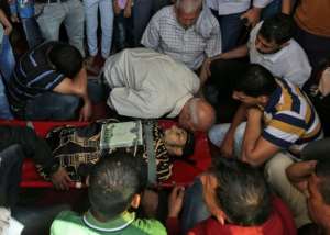 Palestinian mourners gather around the body of a man who was killed during a protest at the Israel-Gaza border on May 14, 2018, during his funeral at a mosque in Khan Yunis in the southern Gaza Strip. By SAID KHATIB (AFP)