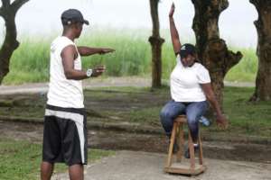Paralympic athlete Audray Fabiola Mengue Pambo uses a wooden stool to warm up for the shot put. By Steeve JORDAN (AFP)