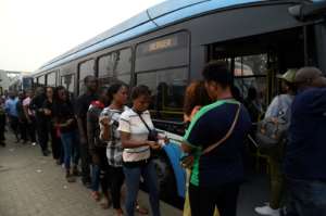 Passengers queue to board a bus provided by the government to offset the impact of the okada and keke ban. Passengers say fares have increased. By PIUS UTOMI EKPEI (AFP)