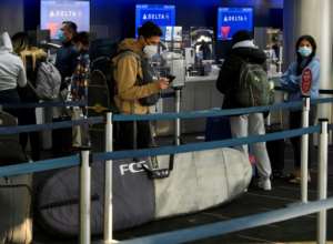 Passengers wait in line to check-in for Delta Air Lines flights at Los Angeles International Airport ahead of the Thanksgiving holiday in Los Angeles, California, on November 25, 2020. By Patrick T. Fallon (AFP/File)