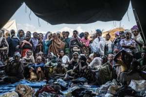 People fleeing violence in the Metekel area gather outside a tent where clothes are distributed at a camp in Chagni, Ethiopia.  By EDUARDO SOTERAS (AFP)